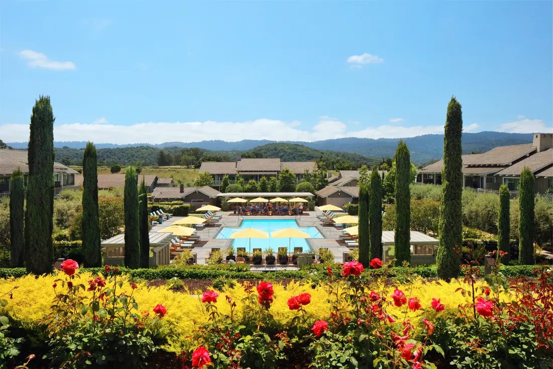 Rosewood Sand Hill pool and gardens framed by roses, with the Santa Cruz Mountains beyond